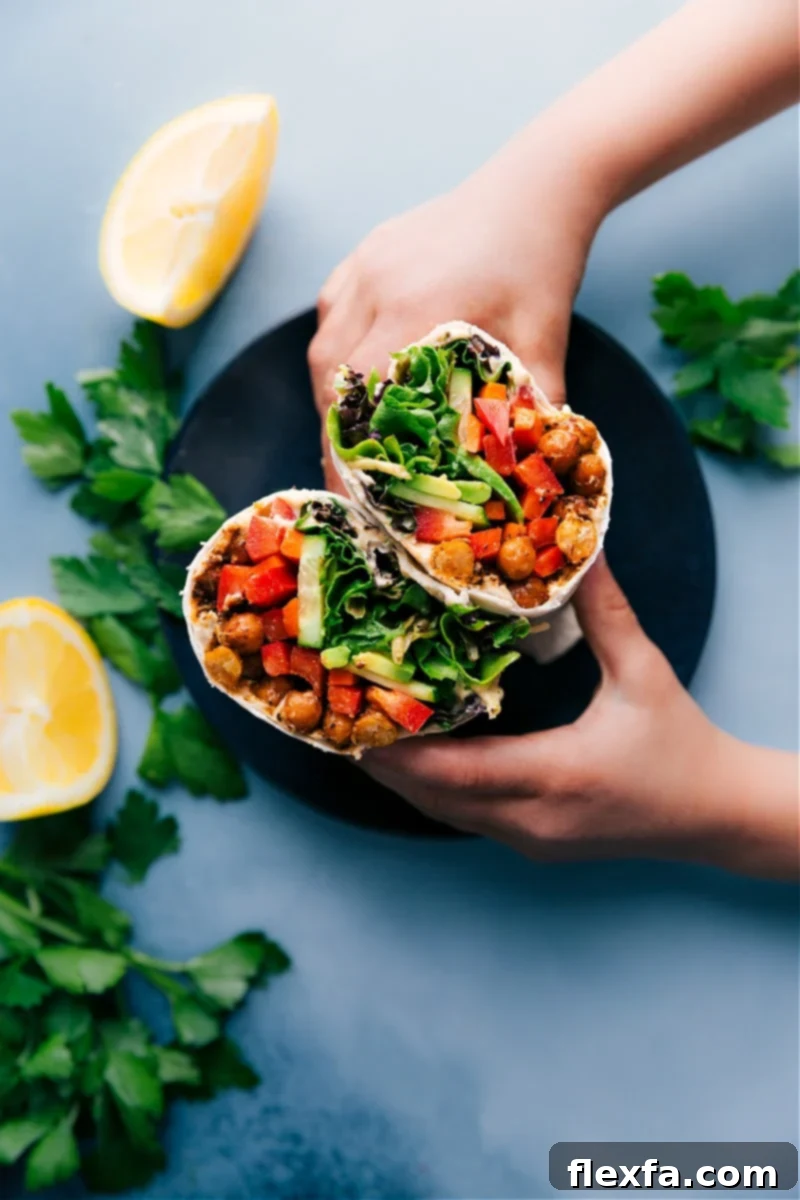 Easy 30-minute Hummus Wraps: Crispy chickpeas, fresh veggies, and smooth hummus-topped tortillas for a healthy and quick lunch or dinner. Recipe via ChelseasMessyApron #healthy #dinner #lunch #quick #easy #simple #best #clean #cleaneating #wholefoods #chickpeas #vegetarian #vegan #hummus #wrap Delicious Hummus Wraps with crispy chickpeas and fresh vegetables, ready to eat.