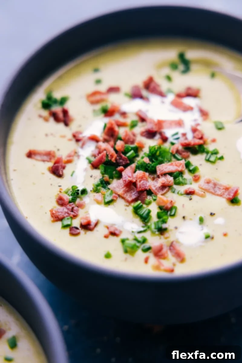 A beautifully presented bowl of creamy and cheesy broccoli soup, ready to be enjoyed. The vibrant green of the broccoli contrasts with the rich yellow of the cheese, promising a delicious and comforting meal.