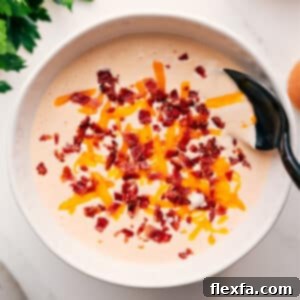 Creamy Cauliflower Soup in a bowl, garnished with fresh herbs.