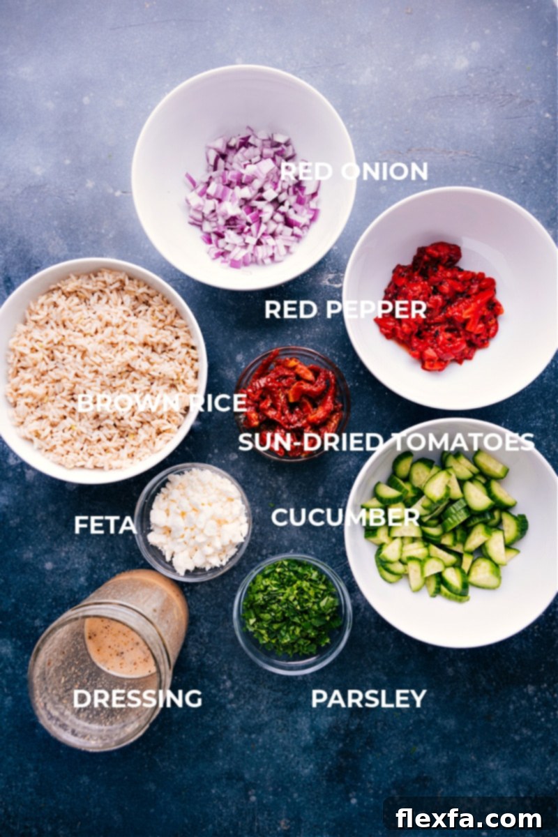 Explore the fresh and healthy ingredients of this Mediterranean Brown Rice Salad! It's packed with crisp cucumbers, sweet roasted red peppers, tangy sun-dried tomatoes, red onion, fresh parsley, and crumbled feta cheese, all designed to be tossed in a bright lemon dressing. Perfect for a delicious and vibrant meal. A curated display of fresh ingredients for Mediterranean Brown Rice Salad: plump cucumbers, vibrant roasted red peppers, rich sun-dried tomatoes, crisp red onion, fresh parsley, and creamy feta cheese.