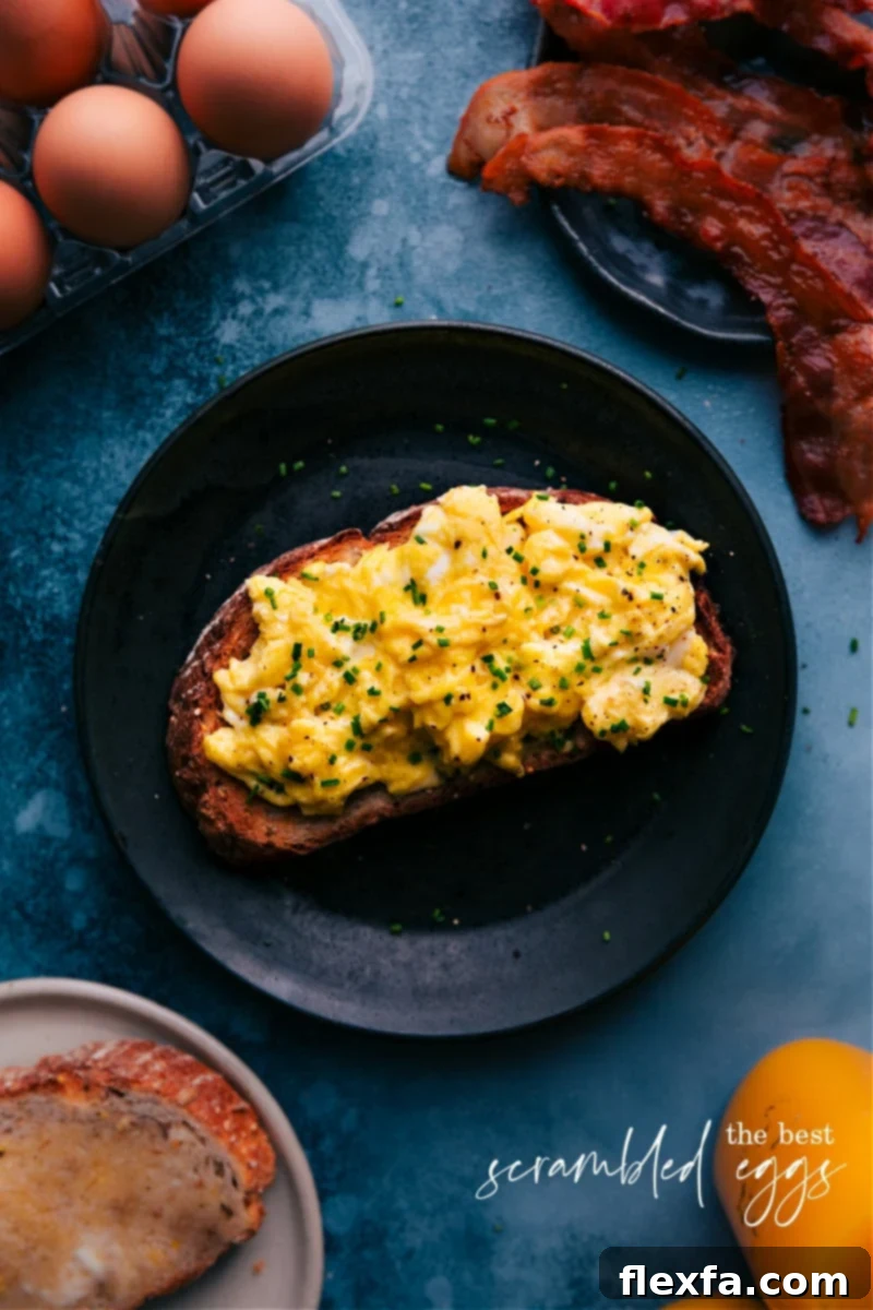 Overhead image of perfectly cooked creamy scrambled eggs garnished with fresh chives, ready to be served for breakfast.