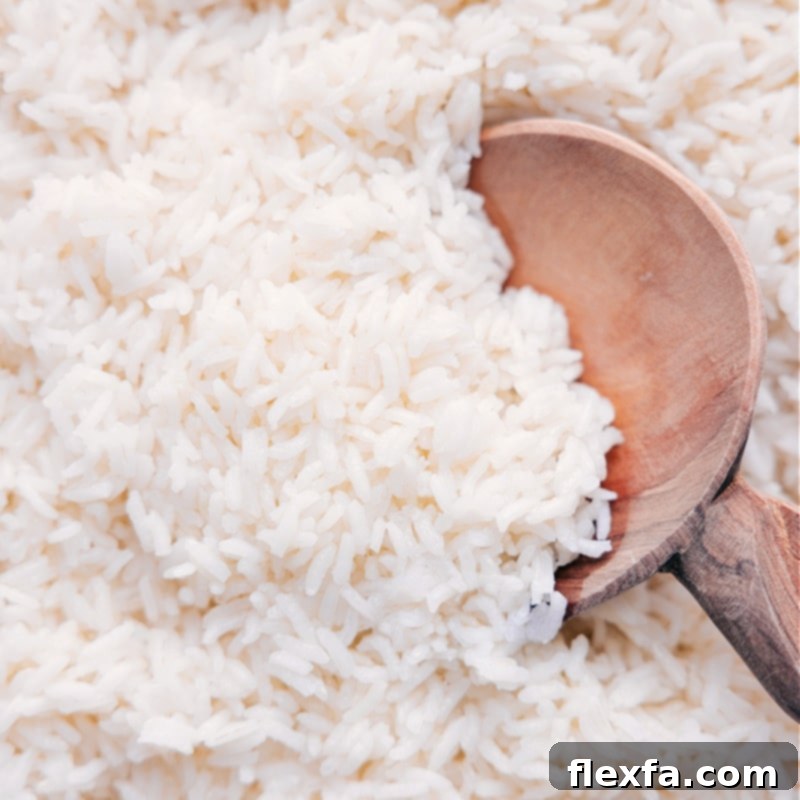 White rice ready to be served. A serving bowl filled with fluffy, steaming white rice, garnished for presentation.