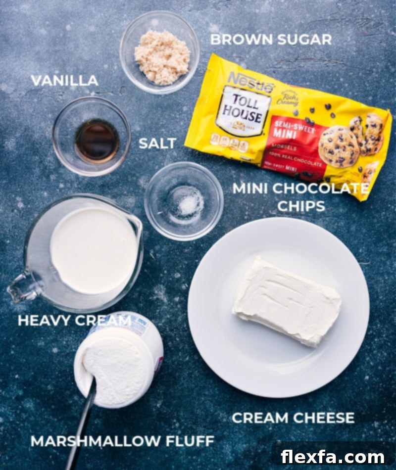 An array of fresh, high-quality ingredients for Chocolate Chip Dip laid out on a clean surface, including a block of cream cheese, bottle of vanilla, brown sugar, salt shaker, marshmallow fluff jar, heavy cream carton, and a bag of mini chocolate chips.