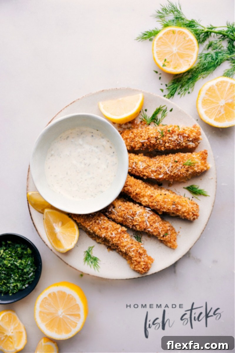 Gourmet Homemade Fish Sticks: Fresh cod, crispy Panko, and savory spices for a delicious family dinner. Overhead image of golden-brown homemade fish sticks, beautifully arranged on a platter, ready to be served with lemon wedges and tartar sauce.