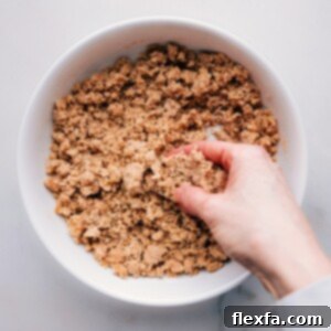Hand kneading streusel mixture to form coarse crumbs.