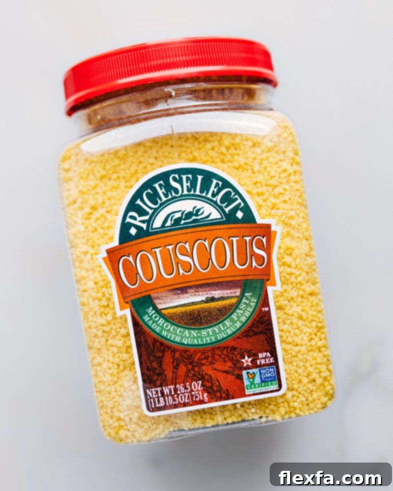 High-quality couscous grains for this recipe. A close-up view of dry Moroccan couscous grains in a small bowl, showcasing their tiny, uniform size and light texture, ready for cooking.