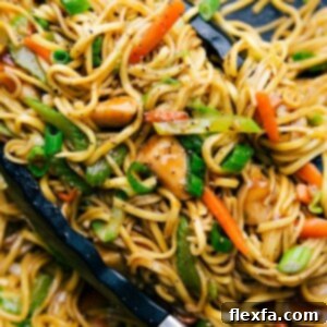 Chicken chow mein in a skillet with tongs, filled with fresh vegetables, perfectly cooked and seasoned.