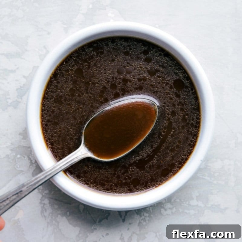 A flavorful sauce being poured over the meal, enhancing the dish with rich and savory flavors.