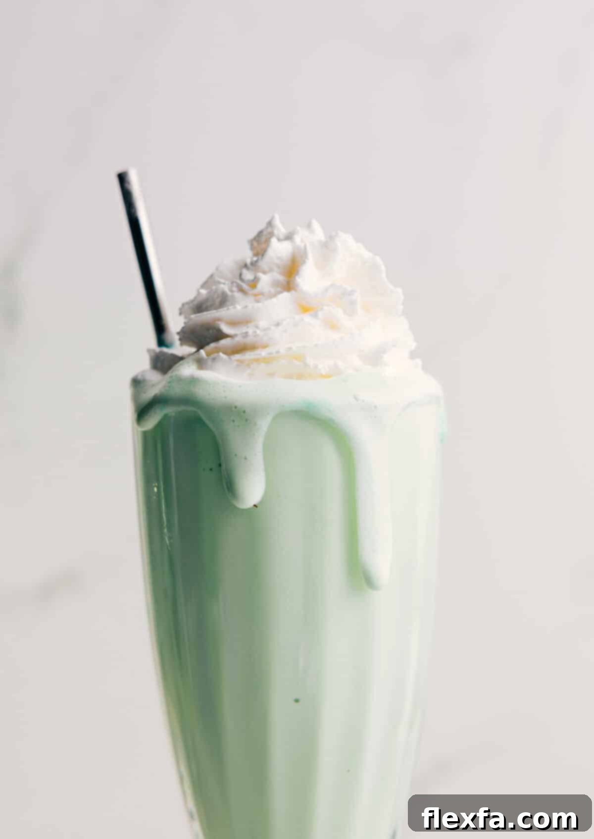 Shamrock Shake topped with fresh whipped cream and a cherry.