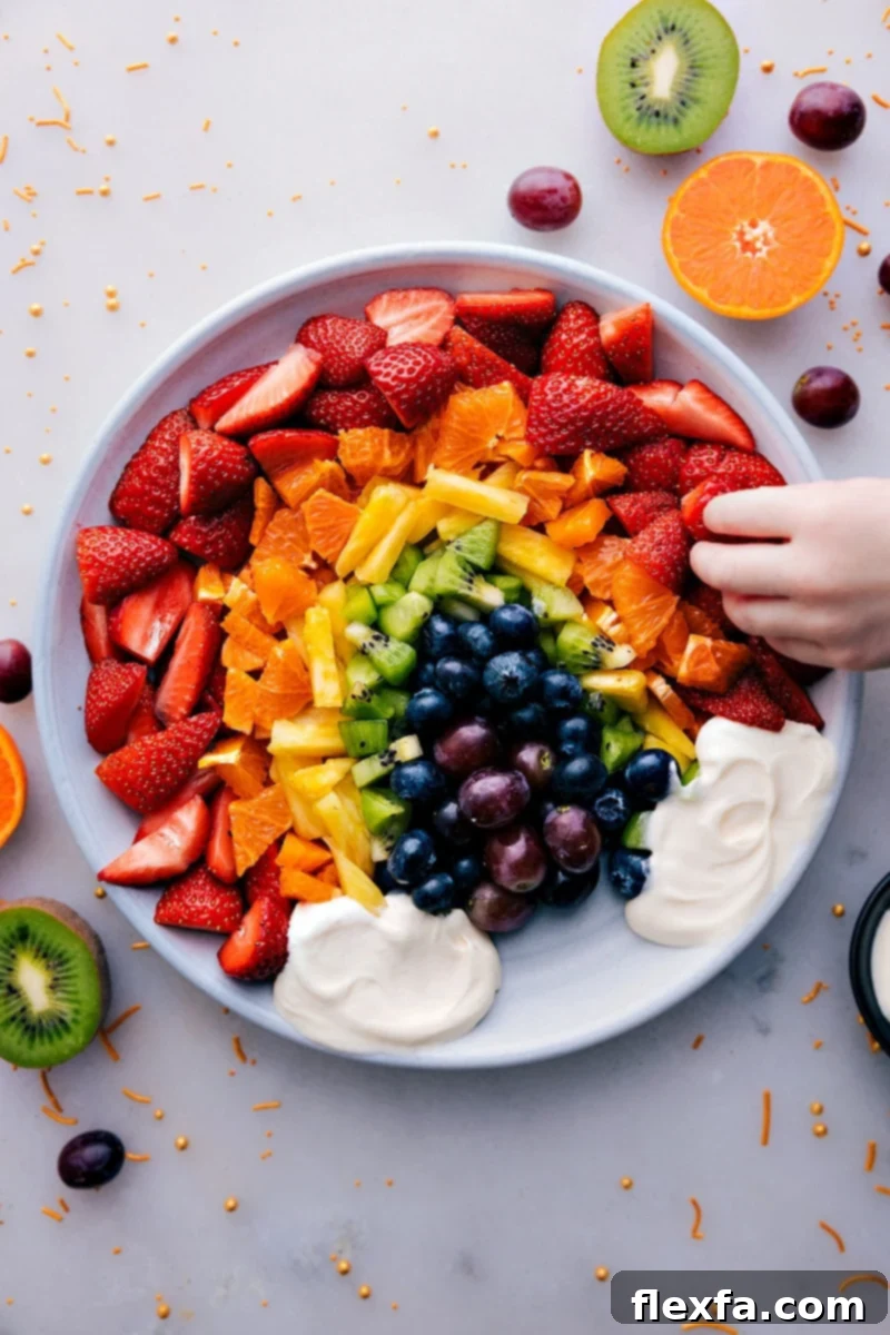 Overhead image of a beautifully arranged Fruit Rainbow Tray with a cloud-like fruit dip.