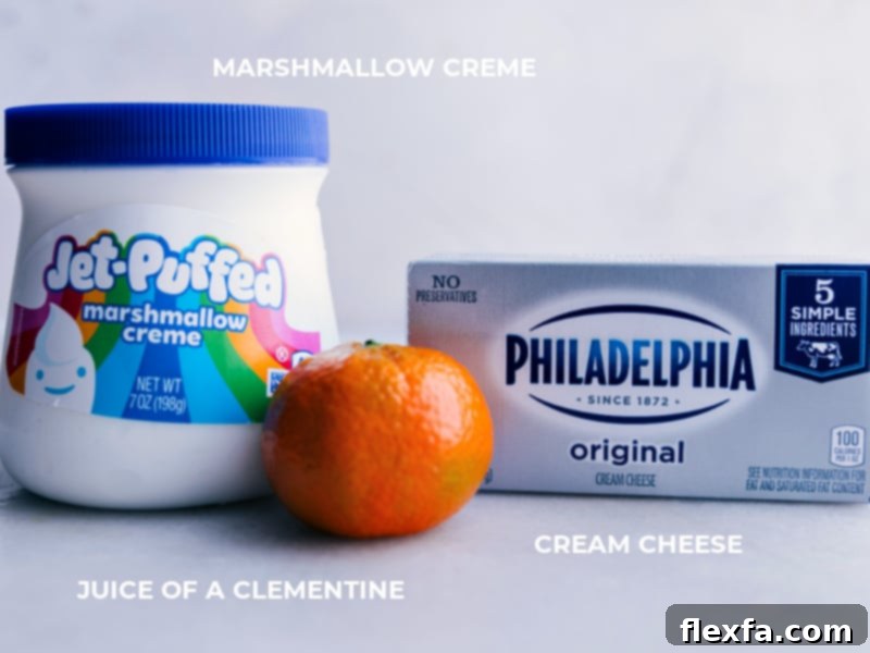 Ingredient shot for the fruit dip, showing marshmallow creme, a clementine, and a block of cream cheese.