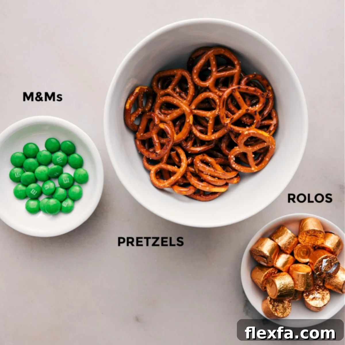 The three simple ingredients—green M&Ms, pretzel snaps, and unwrapped Rolos—prepped for easy assembly of Leprechaun Thumbprints.