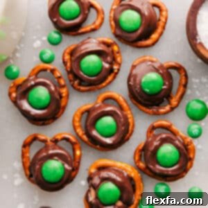 Close-up of three finished Leprechaun Thumbprints with green M&Ms on a white background.