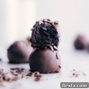 Close-up image of a Mint Oreo Truffle, perfectly coated in chocolate with a sprinkle of mint.