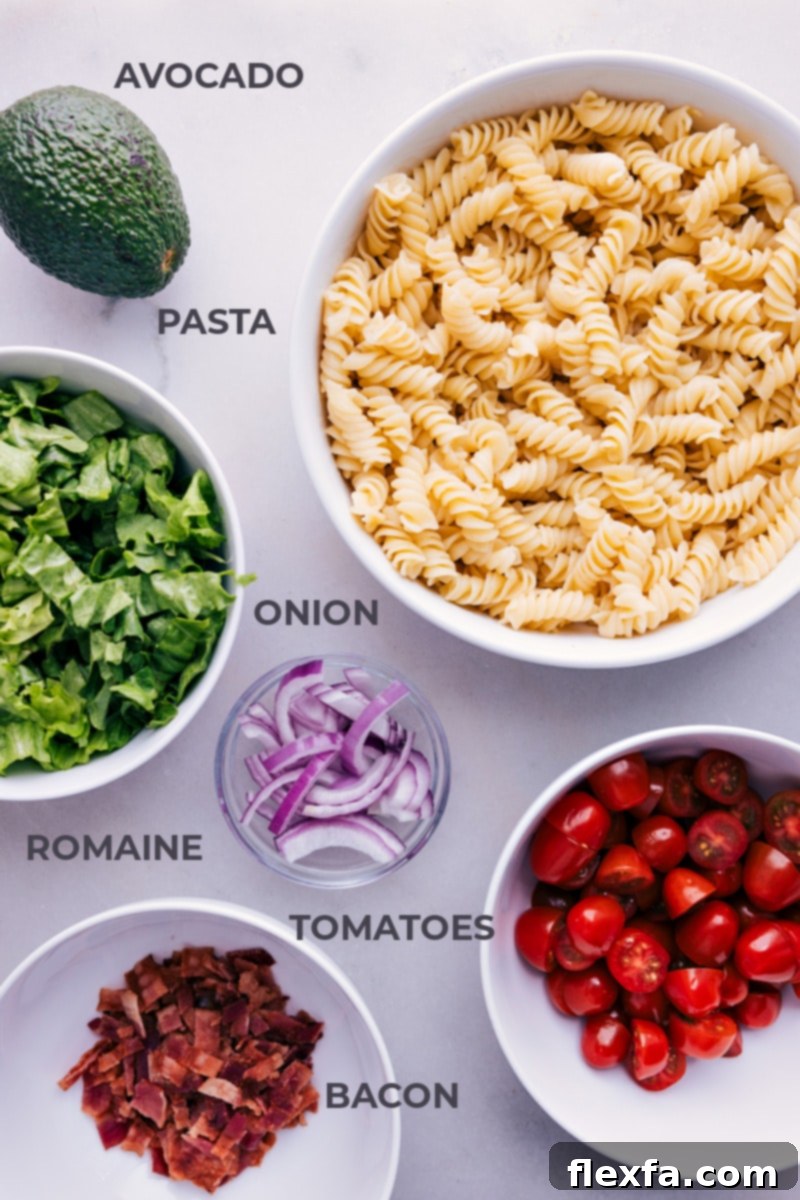 Ingredient shot showing all the fresh components used in the BLT Pasta Salad, including pasta, bacon, tomatoes, avocado, and various dressing ingredients.