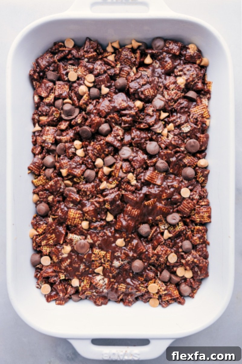 Overhead view of Muddy Buddy Bars mixture being gently pressed into a 9x13-inch pan