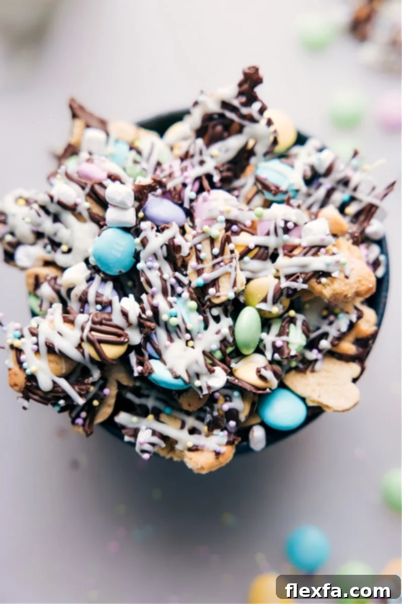Festive Easter Snack Mix with bunny grahams, M&M's, marshmallows, and white chocolate drizzle. An overhead image showcasing the vibrant Easter Snack Mix in a decorative bowl, ready to be enjoyed.