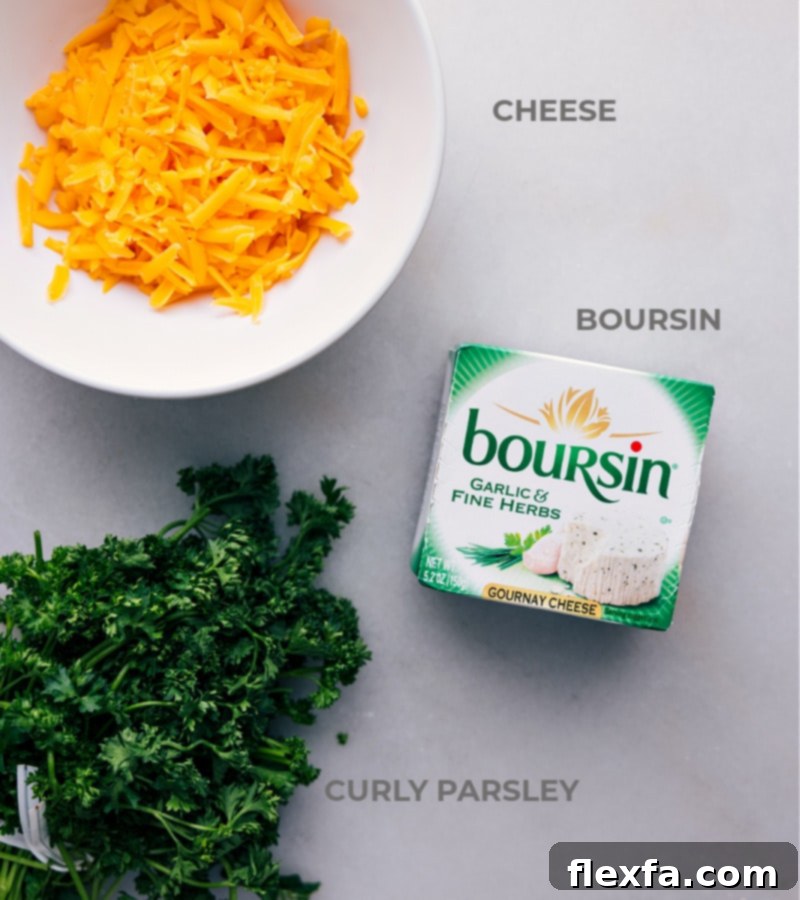 Ingredient shot showing the main components for the Carrot Cheeseball: one package of Boursin Garlic & Herb cheese, a block of sharp Cheddar cheese, and a fresh bunch of curly parsley