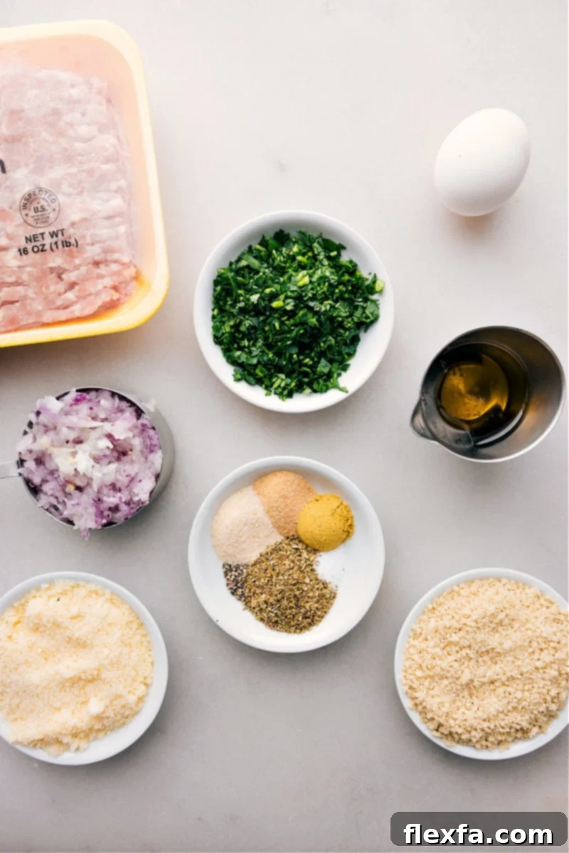 Ingredient shot showing fresh basil, Parmesan cheese, panko breadcrumbs, ground chicken, and other seasonings laid out.