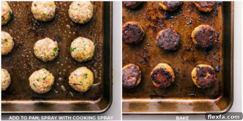 Close-up of chicken meatballs baking on a dark sheet pan in the oven, showing the golden-brown crust.