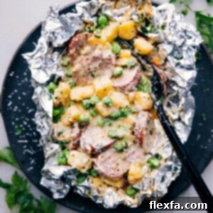 Finished Creamy Sausage and Potato Foil Packs, served with a sprinkle of fresh parsley and Parmesan cheese, ready to be enjoyed.