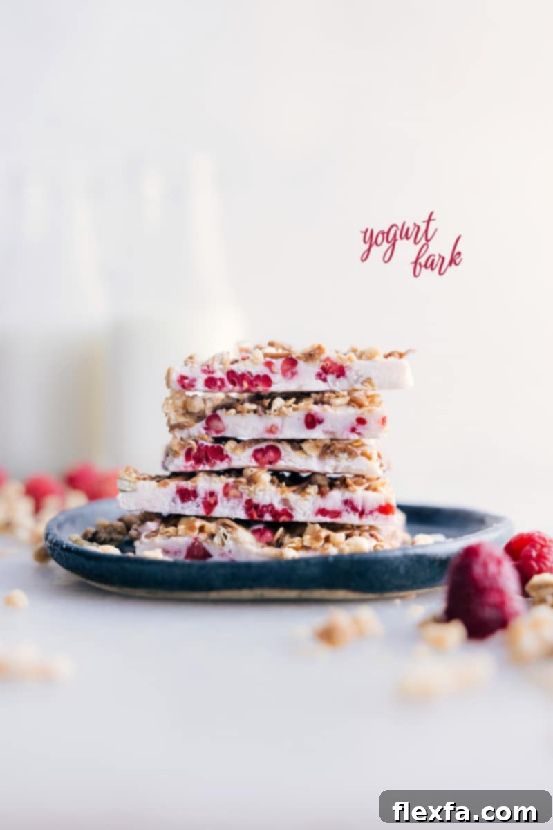 Image of Yogurt Bark pieces stacked on top of each other, showcasing creamy texture and colorful toppings