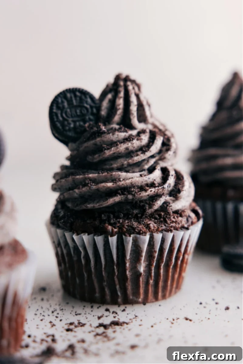 Delicious Oreo Frosting on a cupcake, a sweet and creamy dream. Easy to make, it elevates any dessert. A perfectly frosted cupcake with Oreo Frosting, garnished with an Oreo cookie piece, ready to be enjoyed.