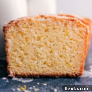 Close-up of a perfectly baked and frosted slice of homemade lemon bread, ready to eat.
