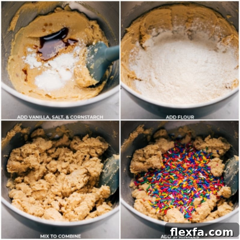 Process shot showing vanilla extract, salt, cornstarch, and colorful sprinkles being added to the creamed butter and sugar mixture in a stand mixer.