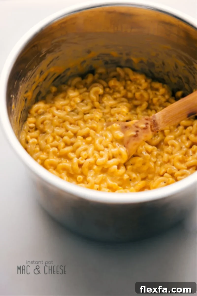 Experience the ultimate Instant Pot Mac and Cheese: incredibly creamy, indulgently rich, and bursting with cheesy goodness, all ready in just 4 minutes of cooking! It's comfort food made effortlessly fast. Overhead image of a bowl of creamy Instant Pot Mac and Cheese, garnished slightly.