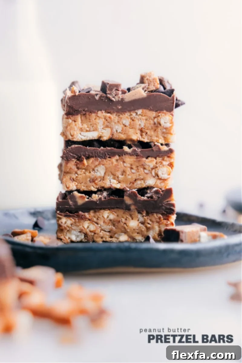 Stacked delicious Peanut Butter Pretzel Bars showing layers of pretzel crust, peanut butter filling, and chocolate topping with sprinkles.