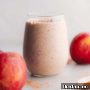 Delicious Protein Apple Smoothie in a glass with cinnamon sprinkle, a perfect healthy breakfast or post-workout drink.
