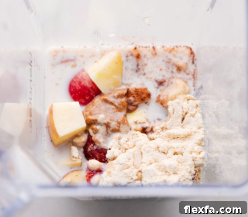 A high-speed blender filled with all the ingredients for a delicious Apple Smoothie, ready to be blended into a creamy, nutritious drink. This image captures the essence of quick and healthy meal preparation.