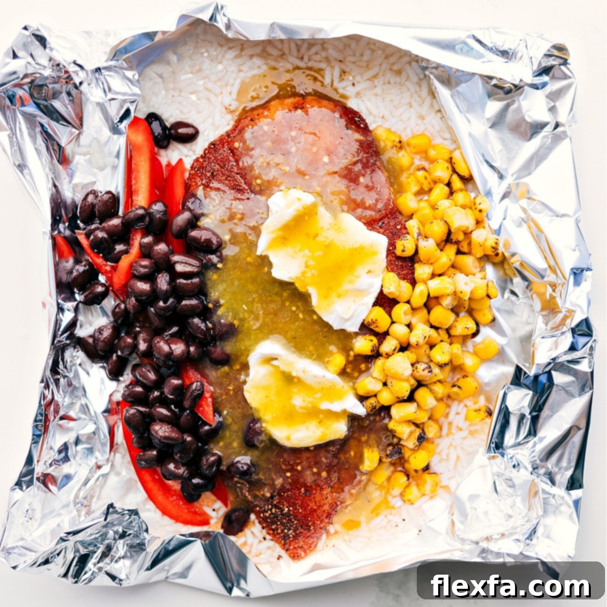 Flavorful And Delicious Chicken Rice Foil Packs Foil packet filled with rice, corn, beans, cream cheese, salsa verde, and chicken, ready to be cooked over a fire, grill, or in the oven.