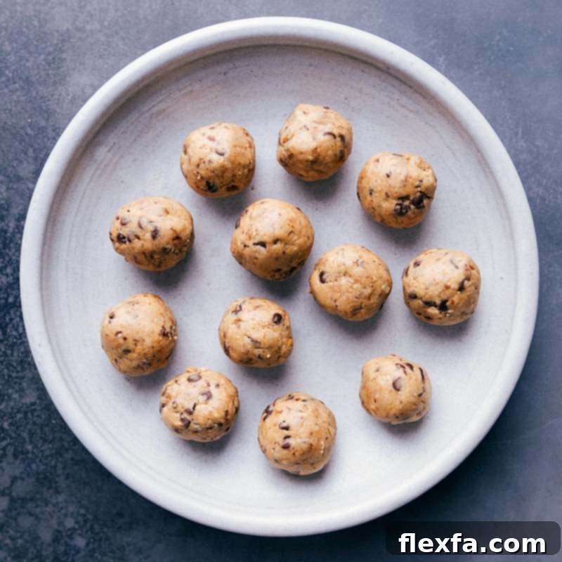 A batch of freshly rolled No-Bake Energy Bites with chocolate chips on a serving plate.
