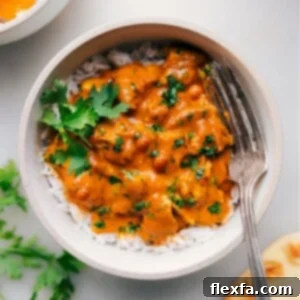 Bowl of creamy instant pot butter chicken served over rice, garnished with fresh cilantro.