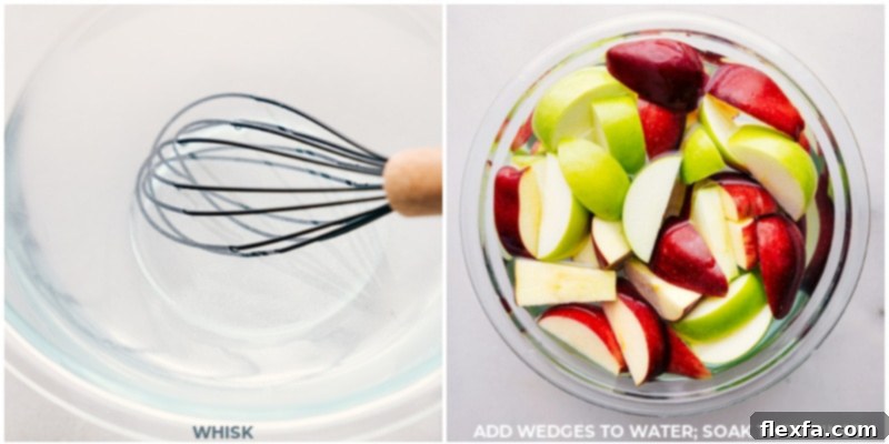 A close-up of apple slices soaking in a saltwater solution, demonstrating the technique to prevent browning for your apple bar.