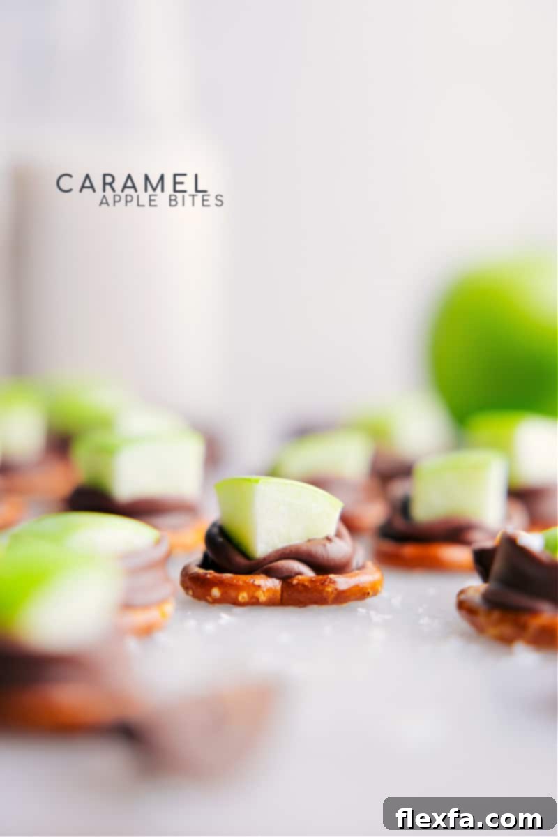 Freshly baked Caramel Apple Bites, glistening with melted caramel and topped with apple slices, ready to be devoured. They sit on a parchment-lined baking sheet.