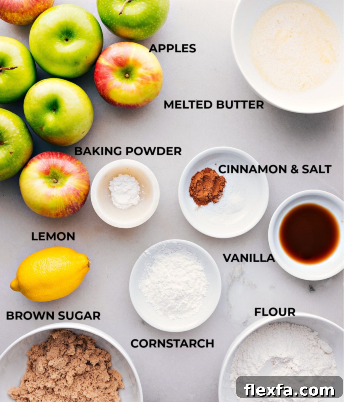 Ingredients prepped out for easy assembly including apples, melted butter, cinnamon, salt, vanilla, baking powder, cornstarch, flour, and brown sugar.
