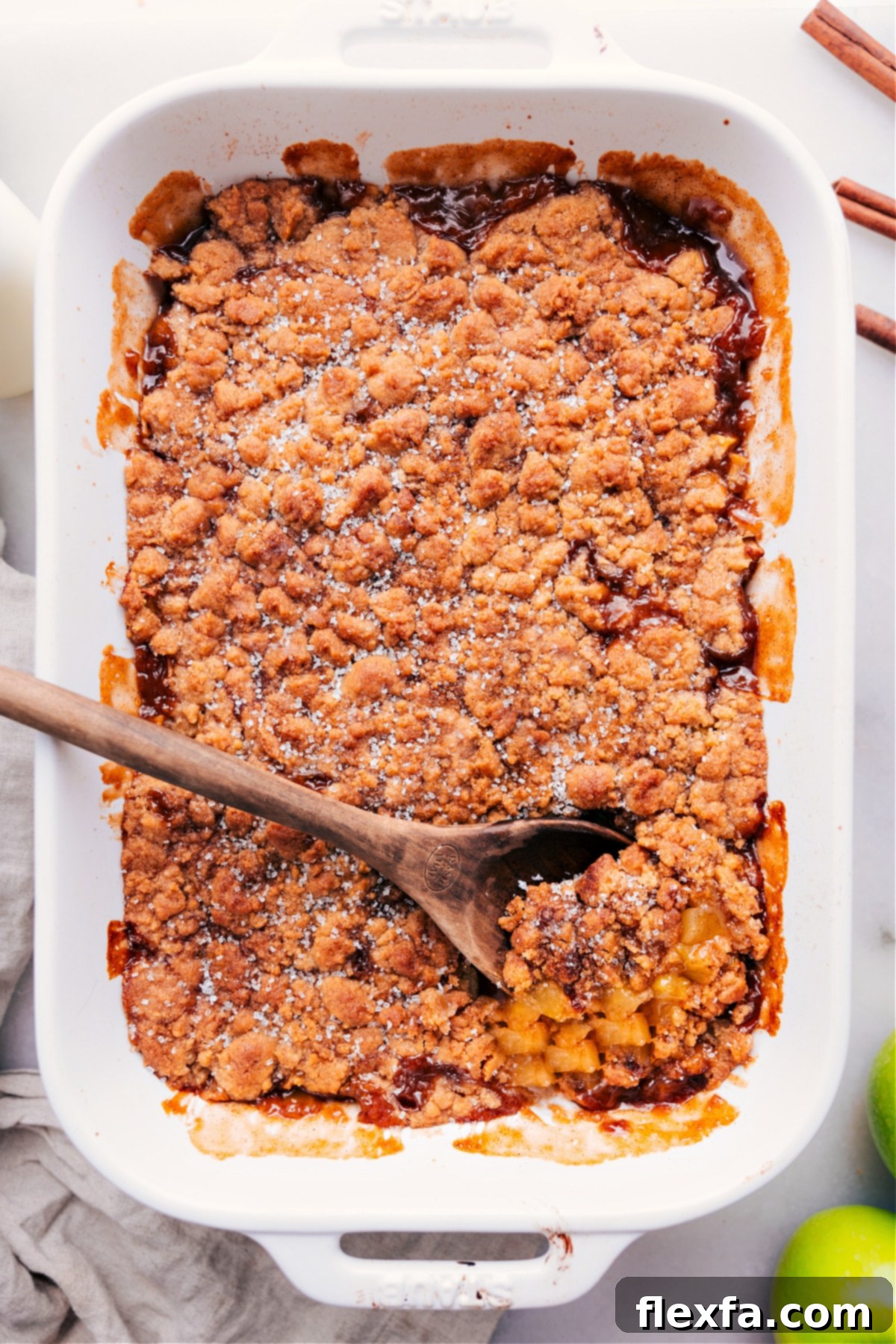 Freshly baked apple cobbler with a spoonful taken out and a spoon in it.