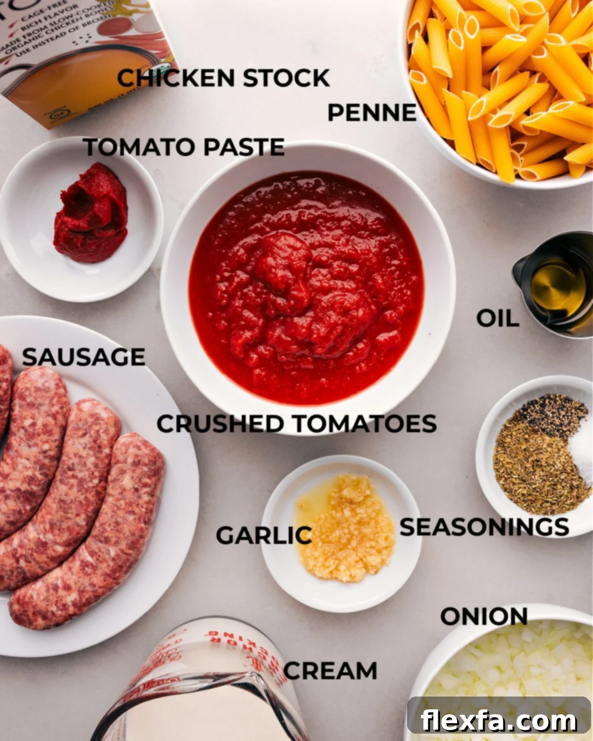 All the fresh ingredients for One-Pot Italian Sausage Penne Pasta, including penne, Italian sausage, crushed tomatoes, heavy cream, onion, garlic, and fresh herbs, meticulously arranged on a rustic wooden board.