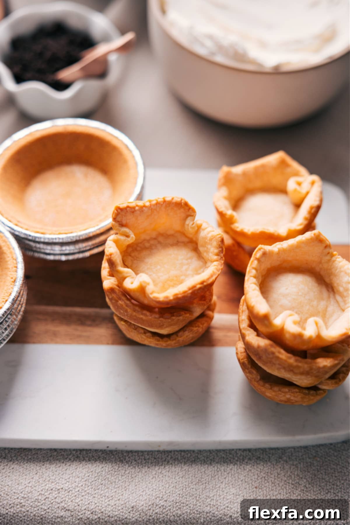 A variety of mini pie crust options, including pre-made graham cracker and classic pastry crusts, and raw pie dough ready for baking, showcasing the flexibility of a customizable dessert pie bar.