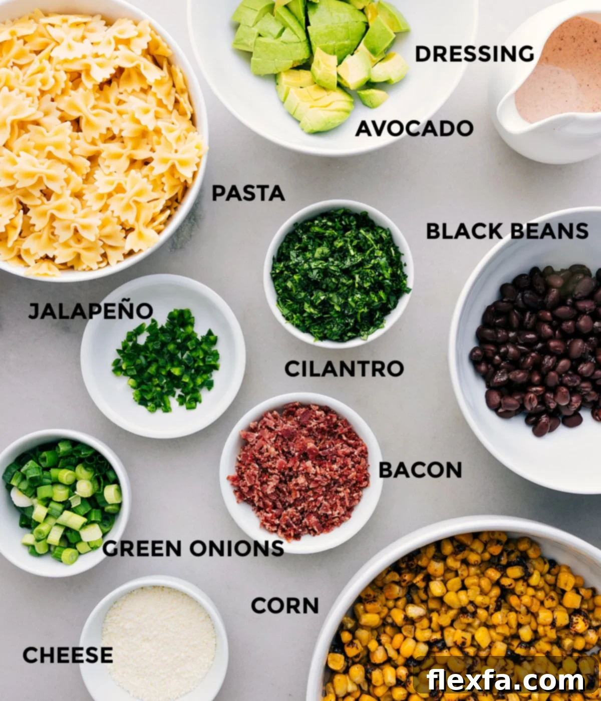 Key Ingredients for Mexican Street Corn Pasta Salad All the fresh ingredients for Mexican Street Corn Pasta Salad neatly prepped and arranged, including vibrant corn, creamy avocado, dark black beans, fresh cilantro, cooked pasta, crispy bacon, green onions, and Cotija cheese.