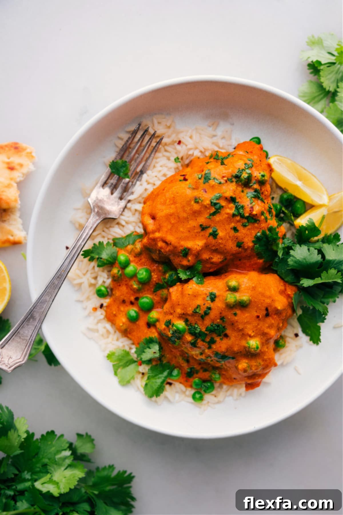 A finished Chicken Tikka Masala dish laid over a bed of rice, delicious, warm, and aromatic.