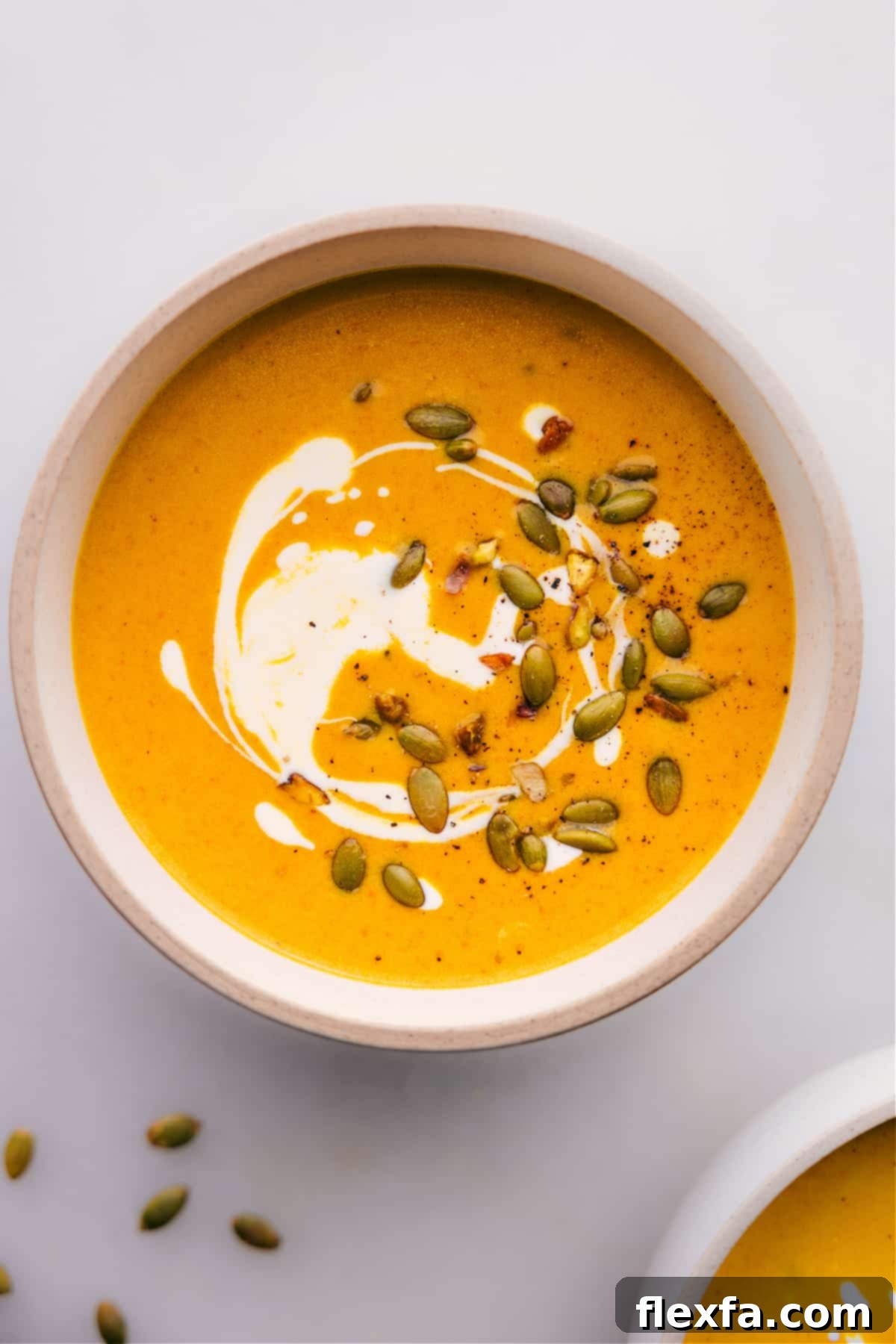 A beautifully garnished bowl of Creamy Pumpkin Curry Soup, ready to be enjoyed.