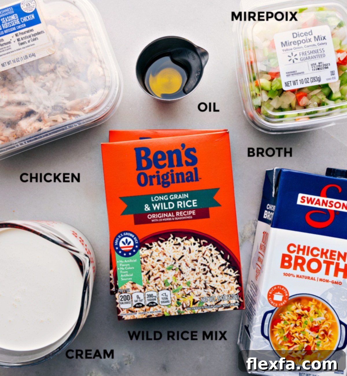 The essential ingredients laid out for making this quick and easy weeknight dinner: mirepoix, wild rice mix, chicken broth, heavy cream, and rotisserie chicken.