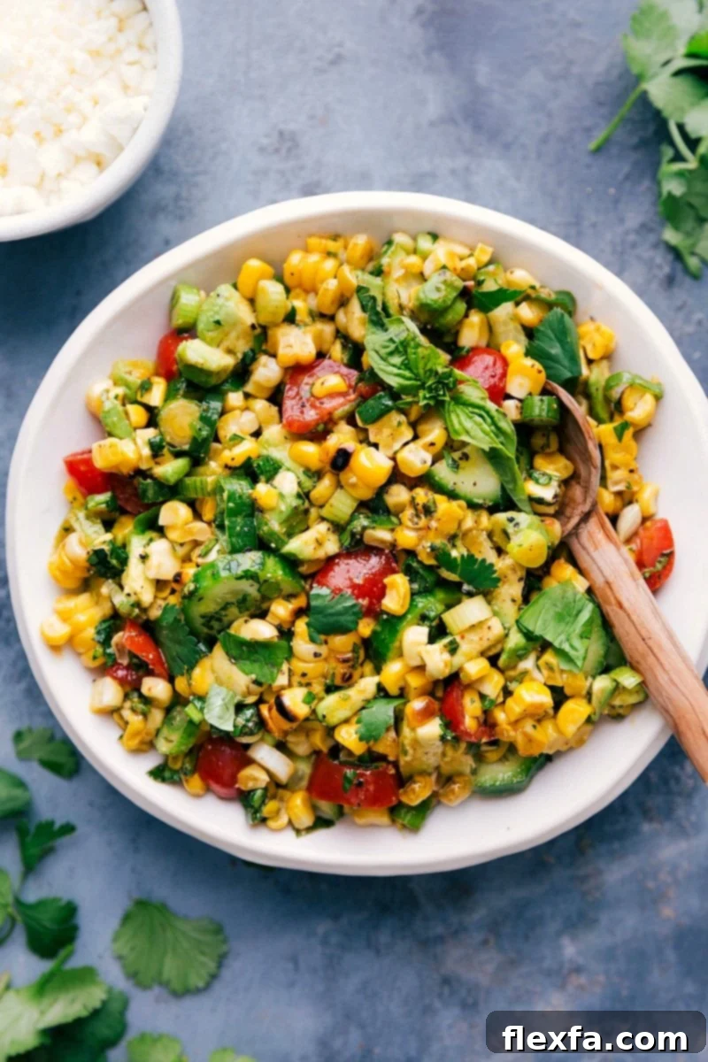 Fresh corn salad in a bowl with a serving spoon.