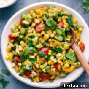 Fresh corn salad in a bowl with a serving spoon.