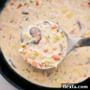 Creamy and rich artichoke soup, with a wooden ladle scooping out a steaming serving ready to be enjoyed.