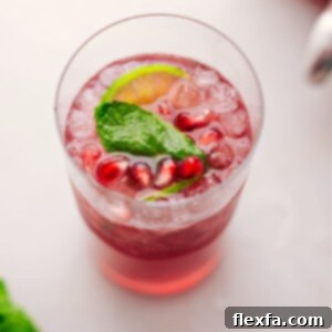 A large glass of Christmas Punch with fresh mint and limes in it, ready for a festive celebration.